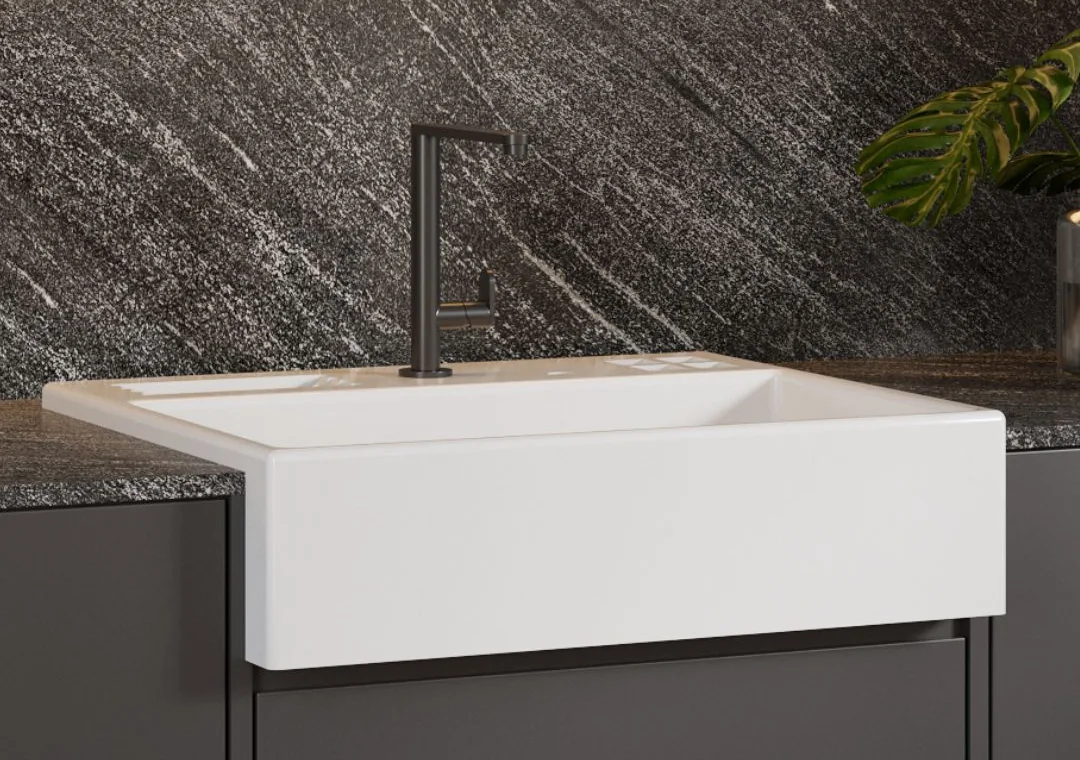 Farm sink em superfície sólida mineral, sob parede de pedra escura